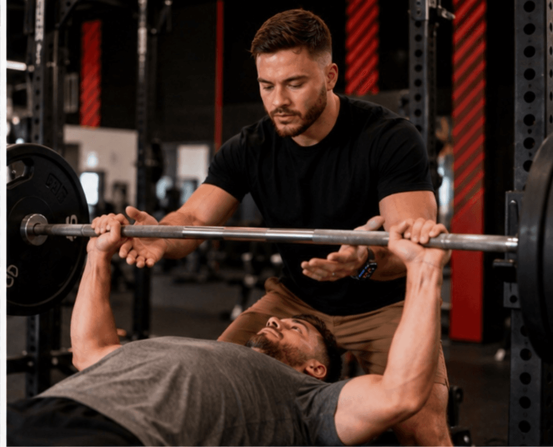 Joseph coaching a client through a bench press