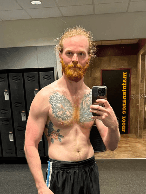 Nick before coaching, standing in a gym locker room